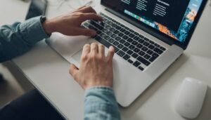 Person wearing long-sleeve top working on laptop