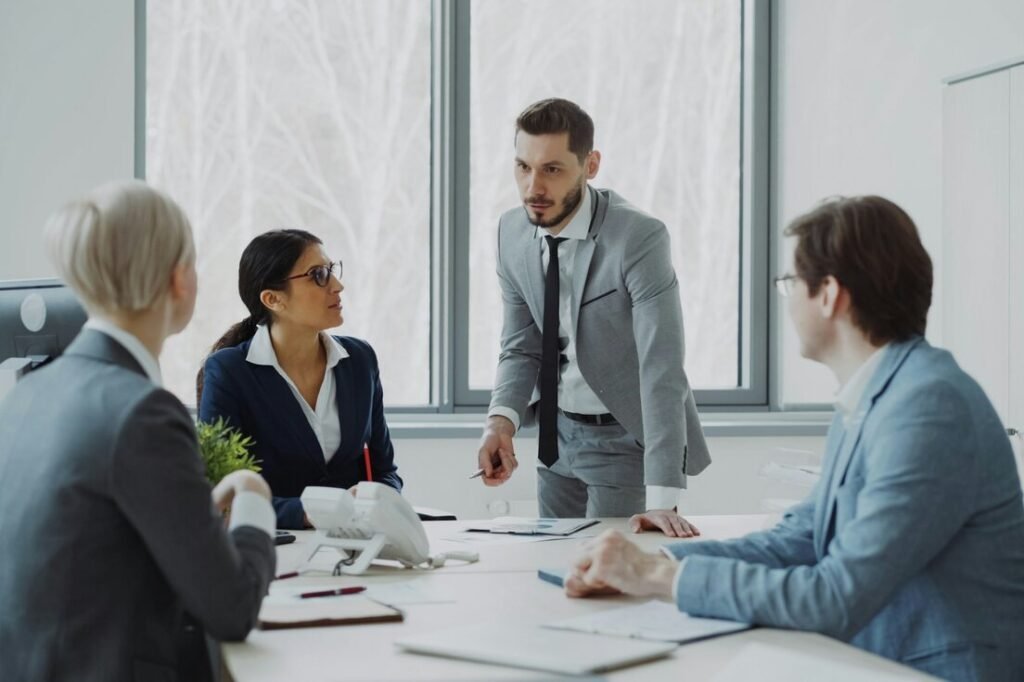 Business team meeting in an office with a manager standing at the table