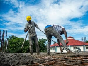 Construction workers pouring concrete on a sunny day