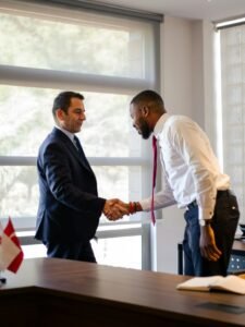 Two businessmen shaking hands across a desk