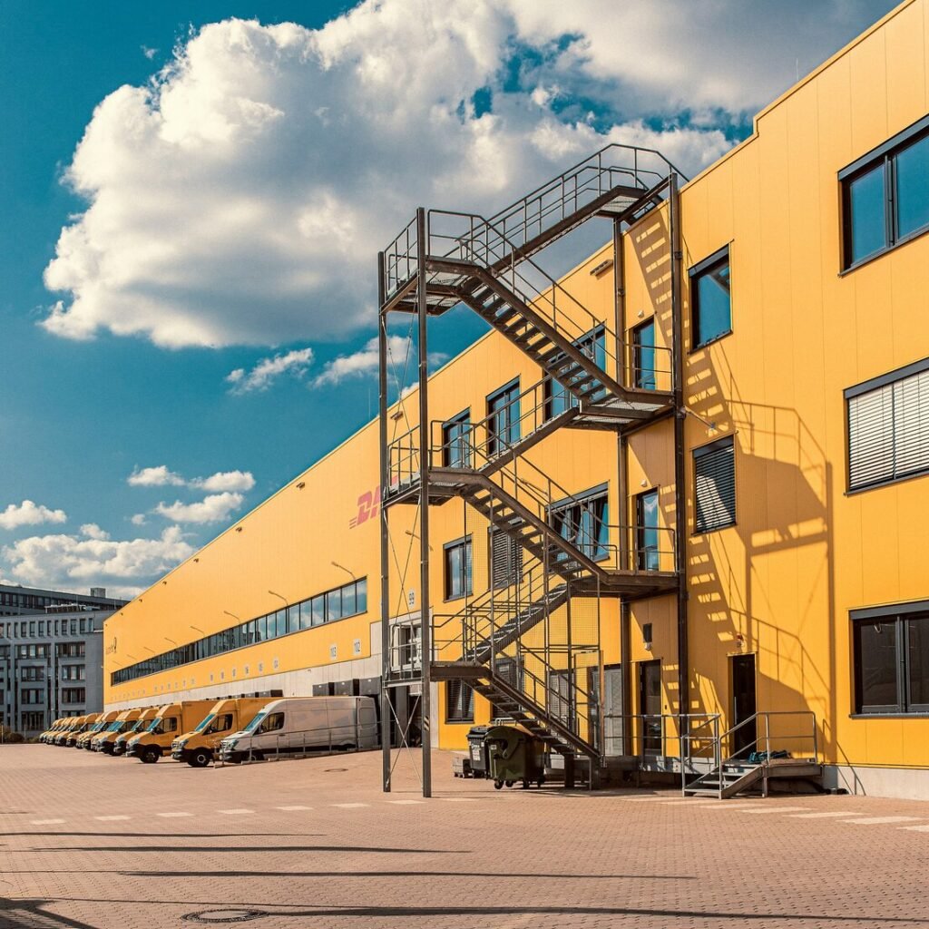 Gray metal staircase on orange DHL building