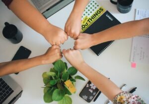 Five fists bumping over office desk