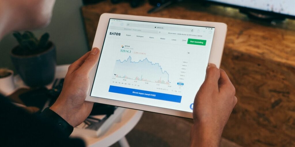 Hands holding a tablet showing a financial chart