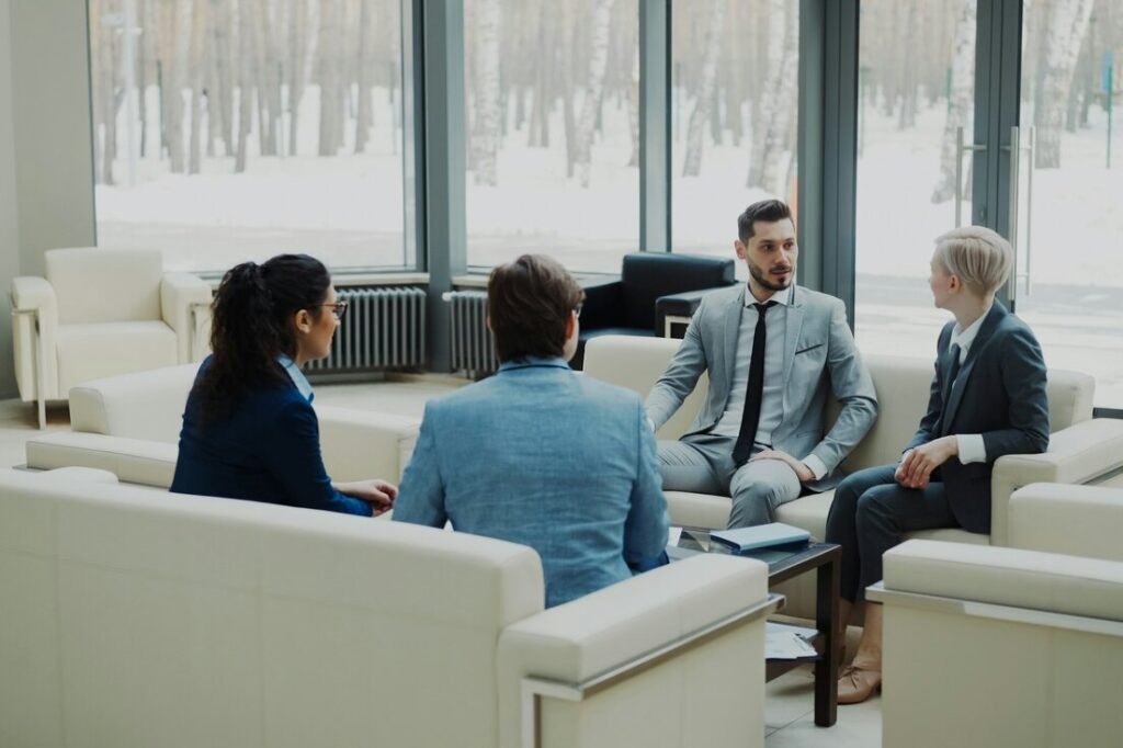 Four professionals in a modern office meeting space