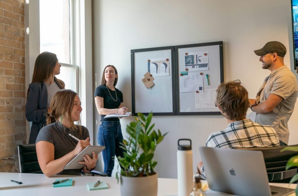 A group of people in a sunlit office during a collaborative workspace meeting