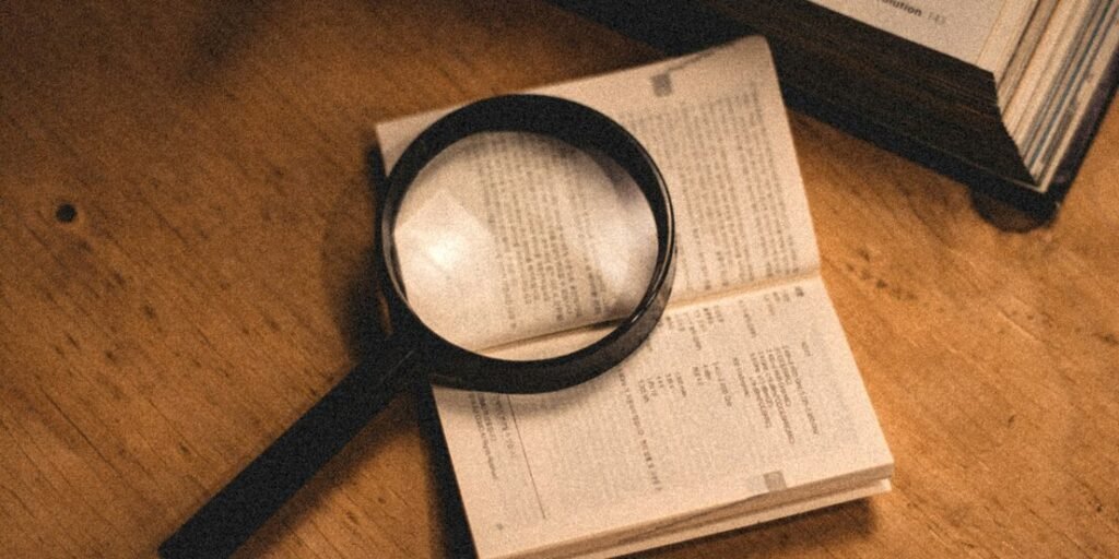 Magnifying glass on an open book on a wooden desk