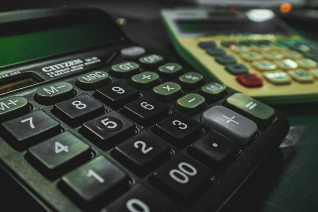 A calculator sitting on top of a table next to another calculator