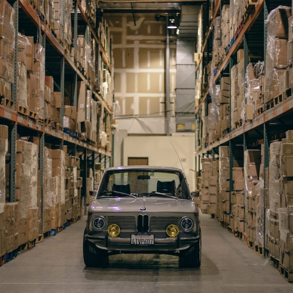 A car parked in a warehouse with boxes on the shelves