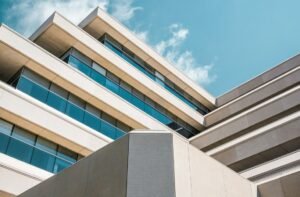 Low angle photo of beige concrete building under cloudy sky