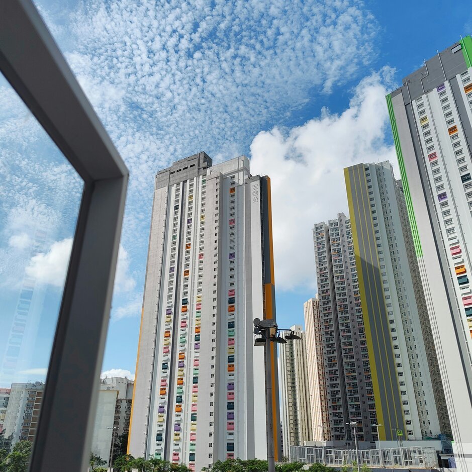 Modern apartment buildings under a cloudy blue sky
