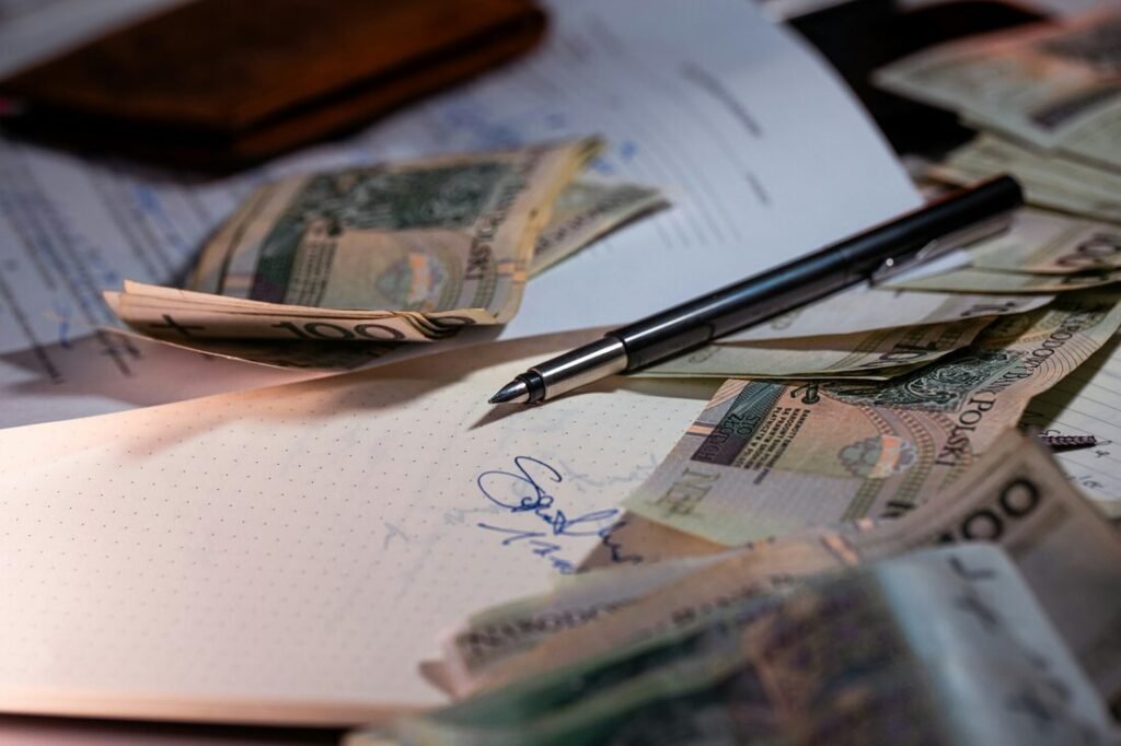 Pen, papers and banknotes on a desk, illustrating cash flow