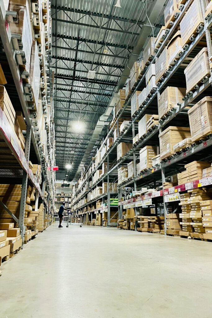 Tall shelves filled with cardboard boxes in a warehouse aisle