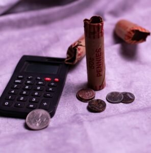 Calculator and rolls of pennies with loose coins