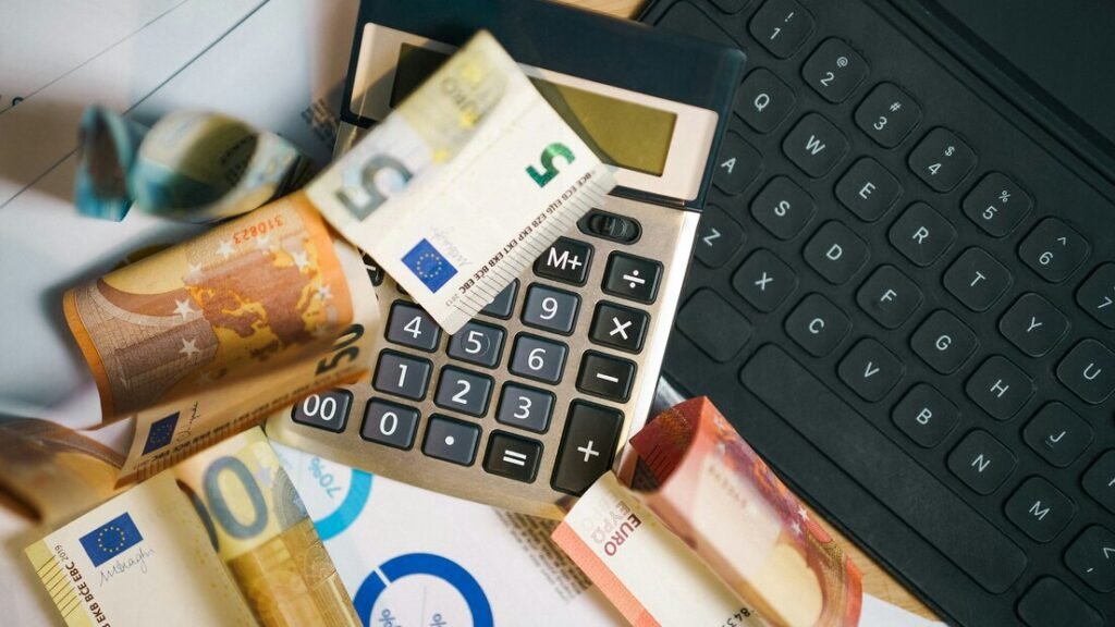 A calculator sitting on top of a pile of money