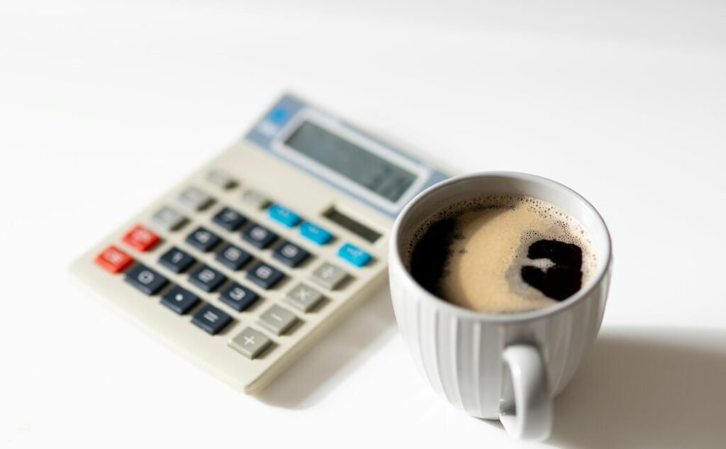 A cup of coffee next to a calculator