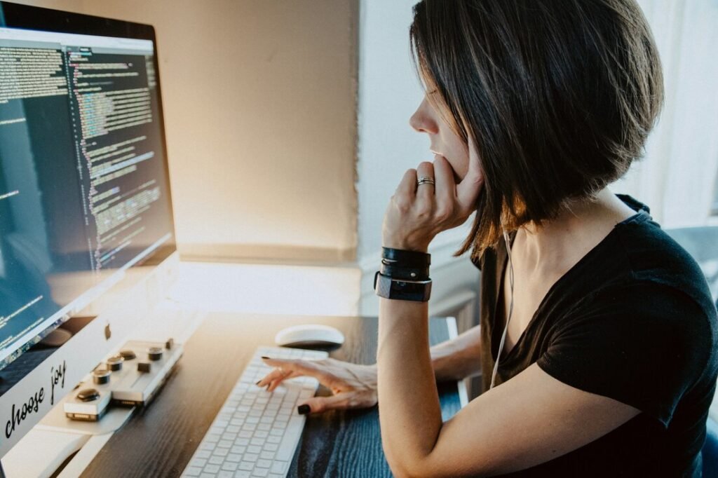 Woman concentrating while looking at a computer screen with code