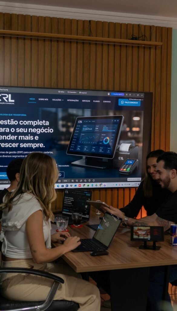 Colleagues collaborating around a table with a large screen display
