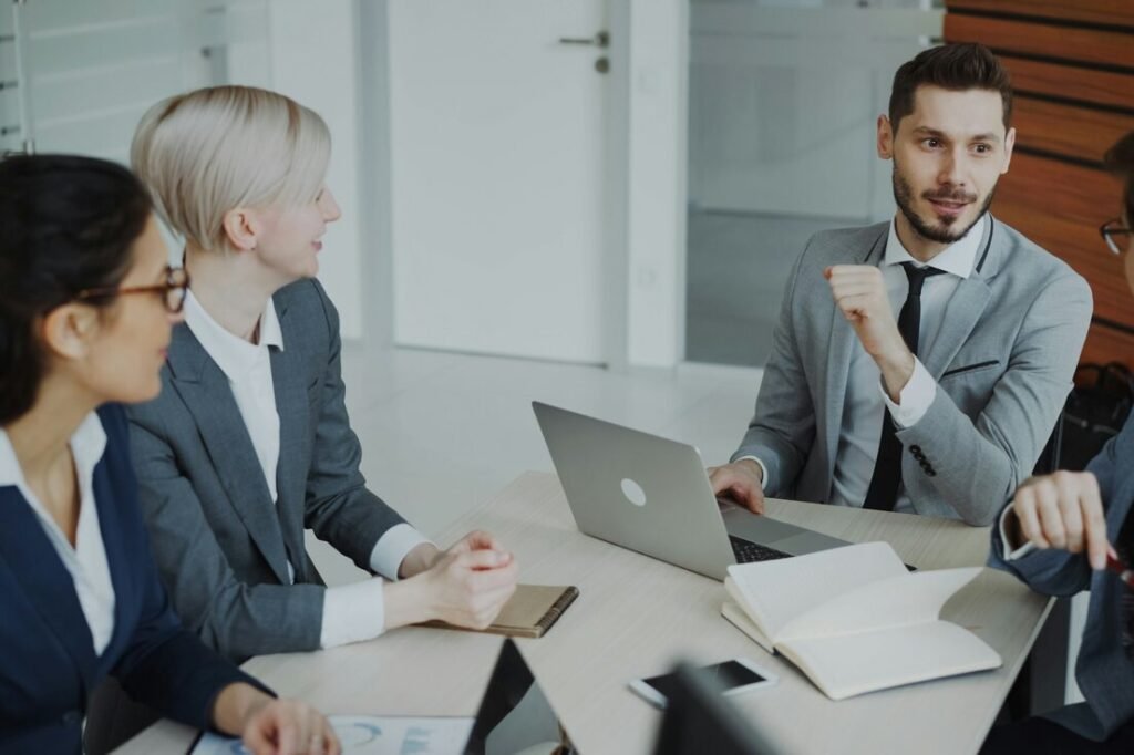 Four professionals in a business meeting around a table