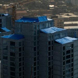A tall building with a crane in the background