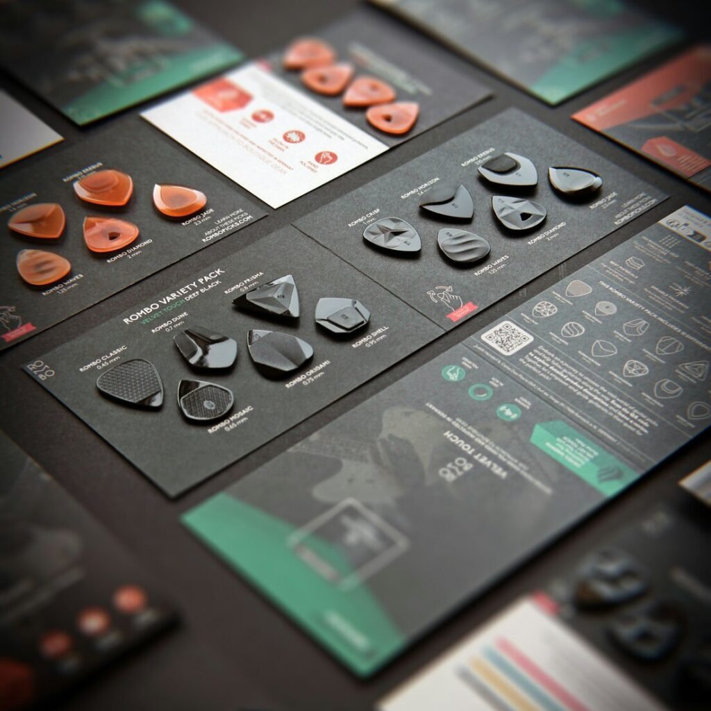 Various guitar picks displayed on black cards with information