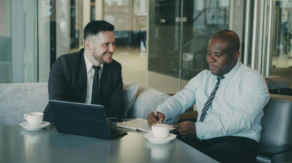 Two businessmen discussing documents over coffee