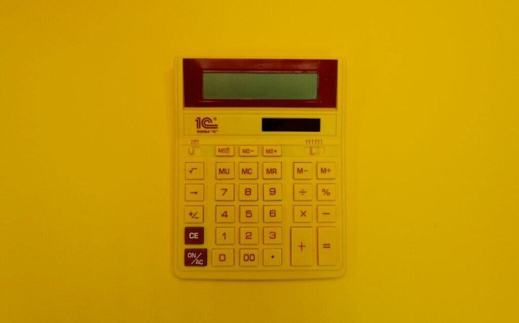 A calculator mounted on a yellow wall