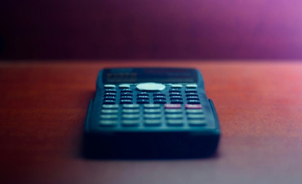 Black desk calculator on brown wooden table