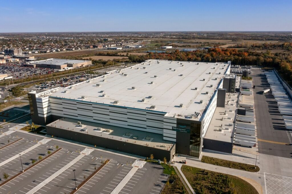 Aerial view of a large industrial warehouse building with parking