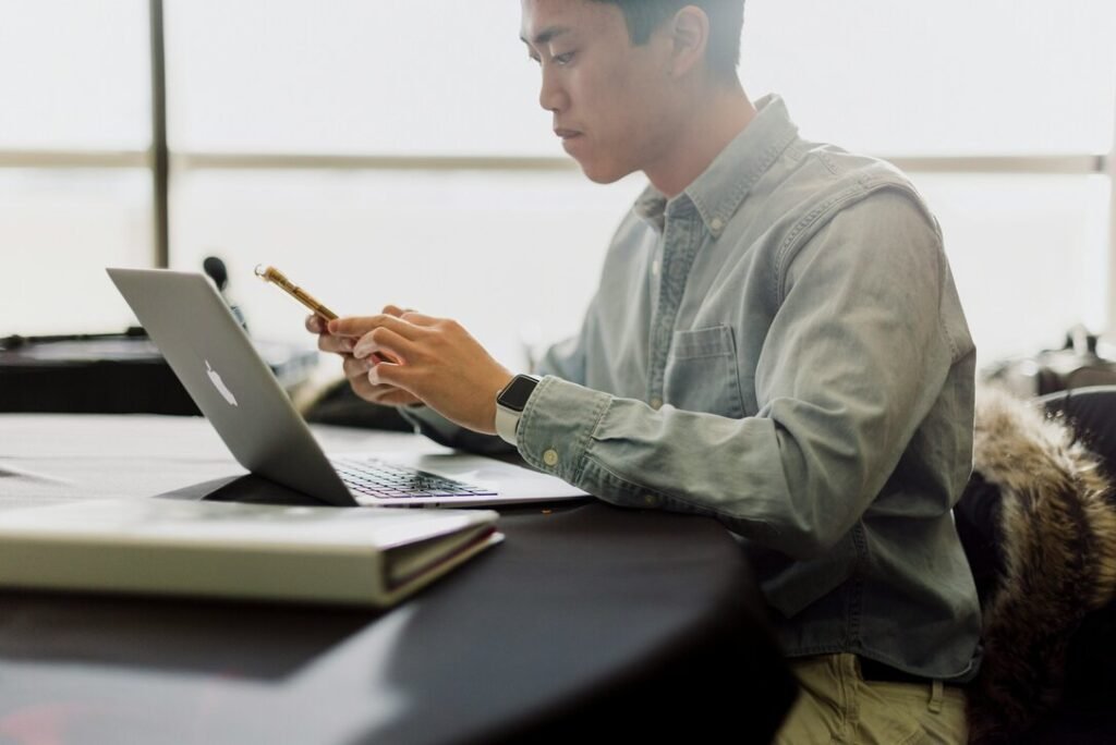 Man working on a laptop at a desk in a bright office