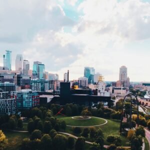 Aerial view of the Minneapolis skyline above a green park with trees