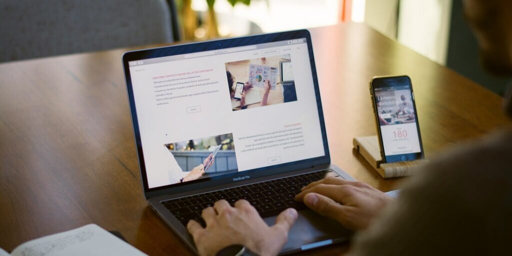 Person sitting near chain while using MacBook Pro