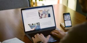 Person sitting near chain while using MacBook Pro