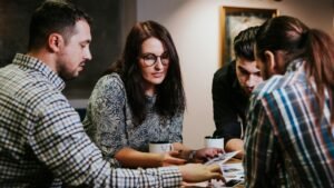 Four people reviewing documents at a wooden table in a workspace
