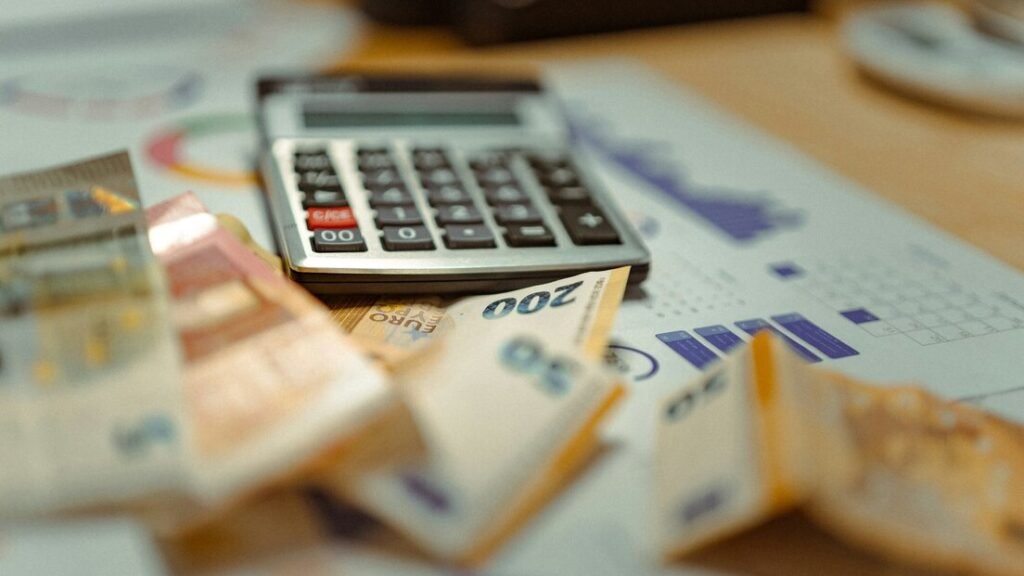 A calculator sitting on top of a pile of money